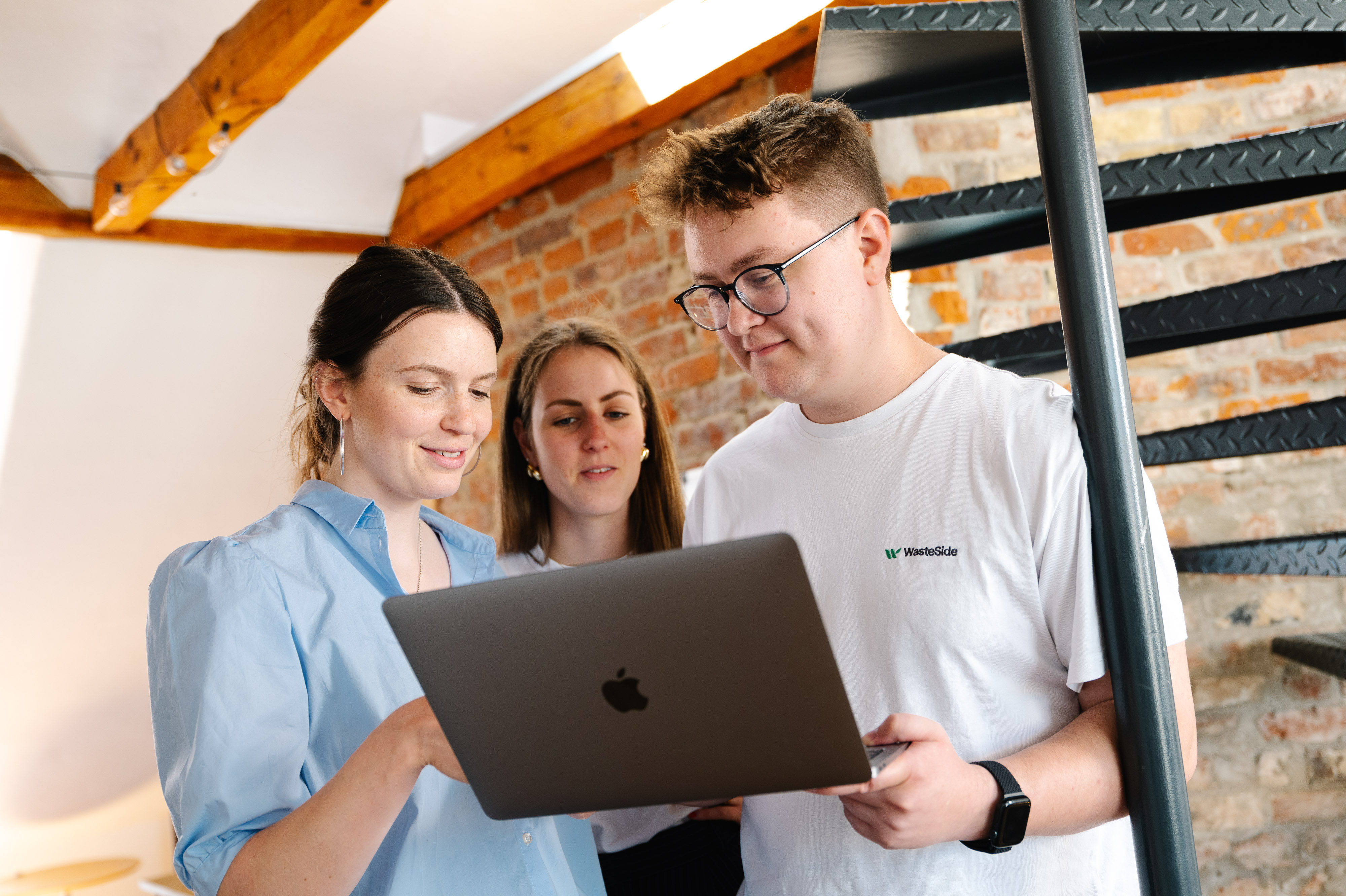 Das WasteSide-Team arbeitet gemeinsam an einem Laptop